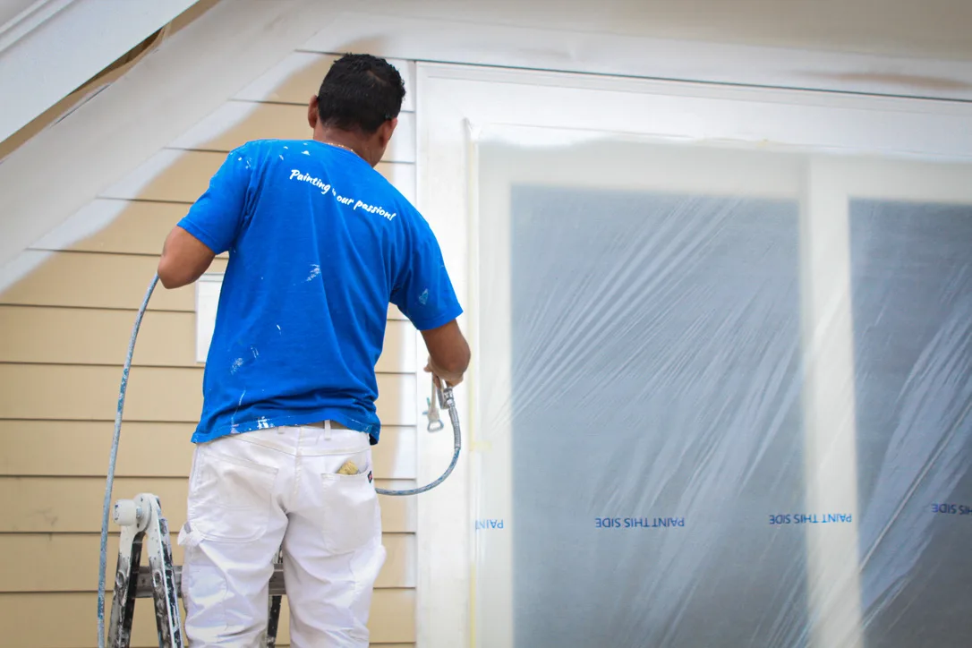 Crew spraying exterior siding
